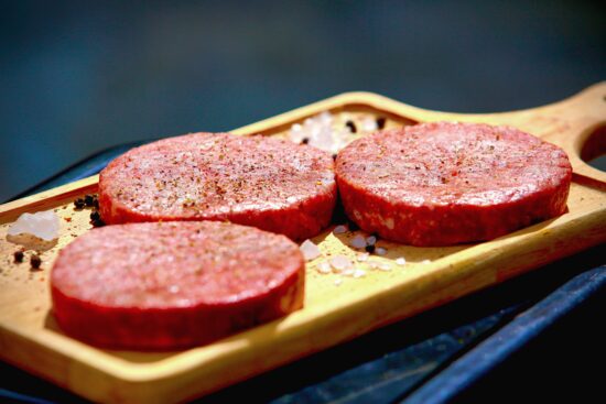 Steak haché cru sur planche — principal vecteur de contamination E. coli et EHEC